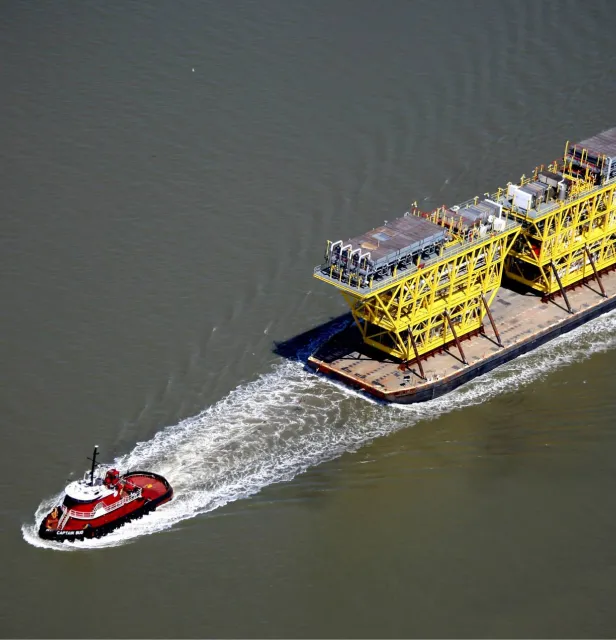 barge being towed by a small boat
