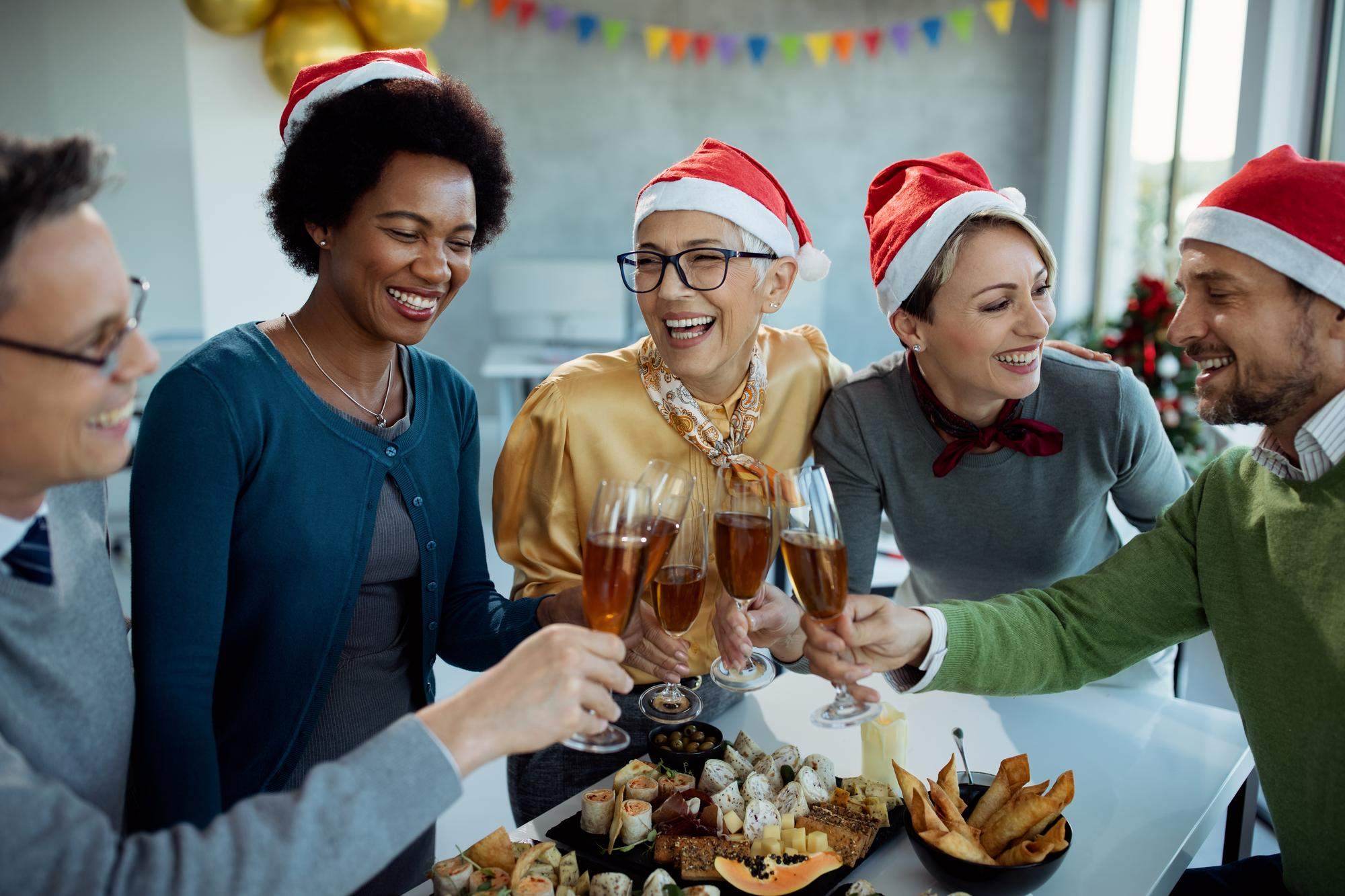 Mitarbeitende stoßen an der Weihnachtsfeier an