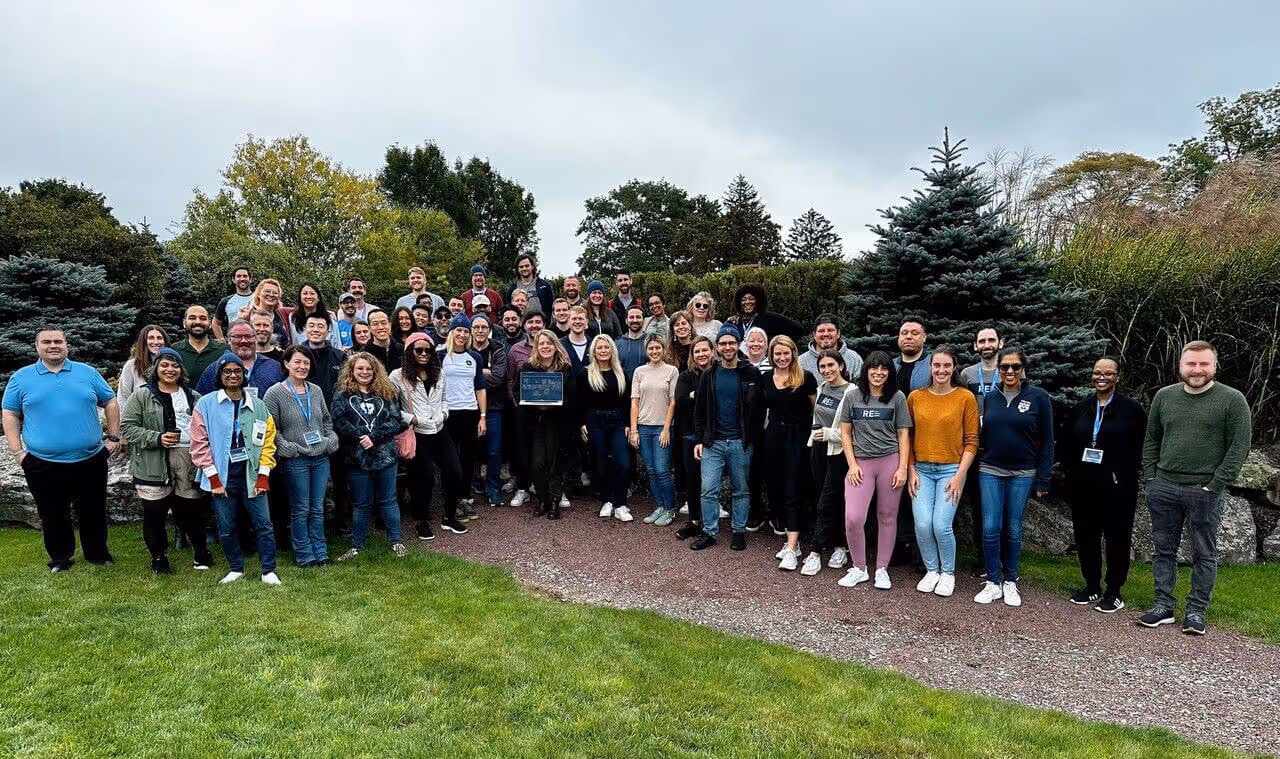 A diverse group of individuals standing in front of a majestic building, showcasing unity and admiration.
