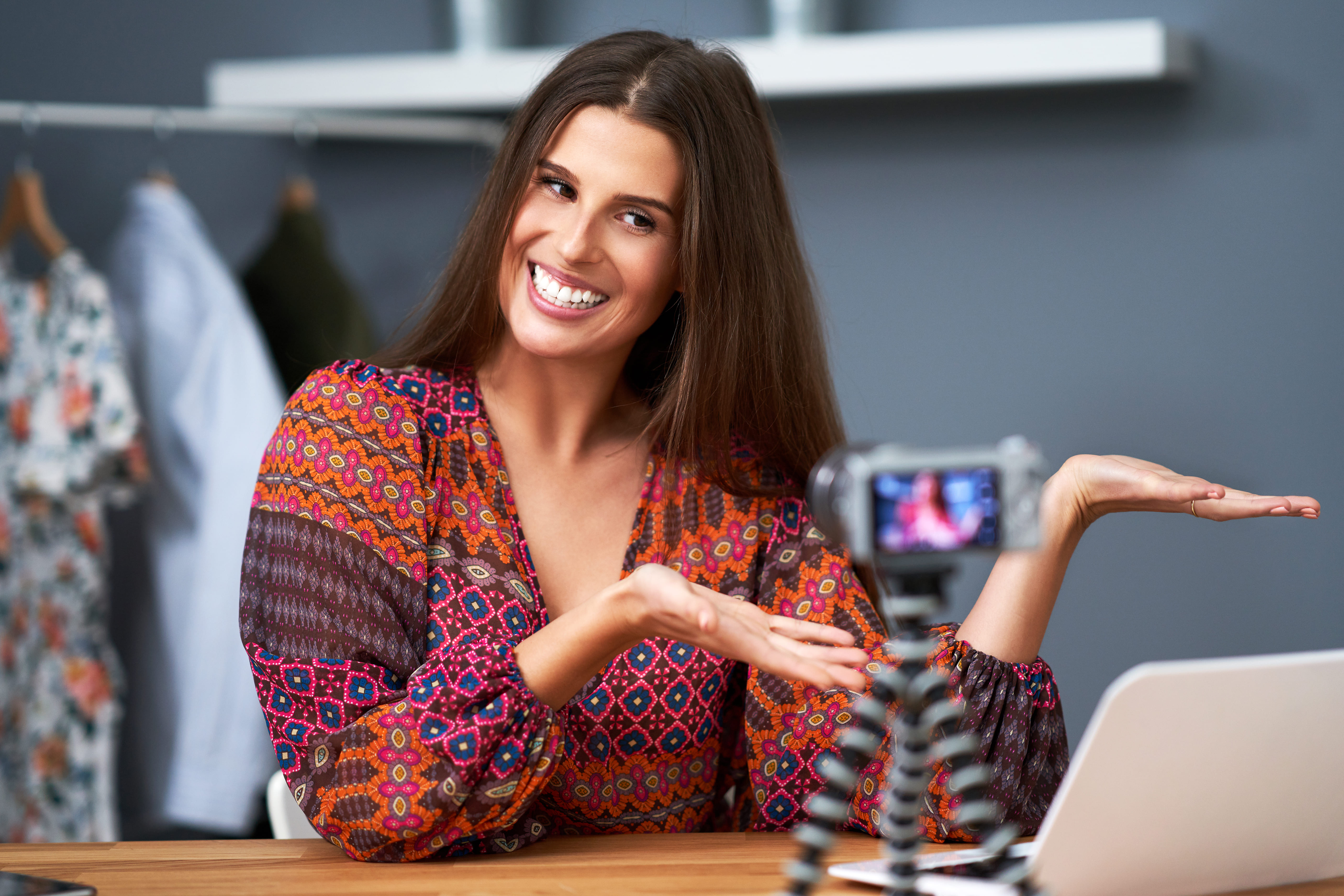 Frau sitzt vor Kamera als Influencerin