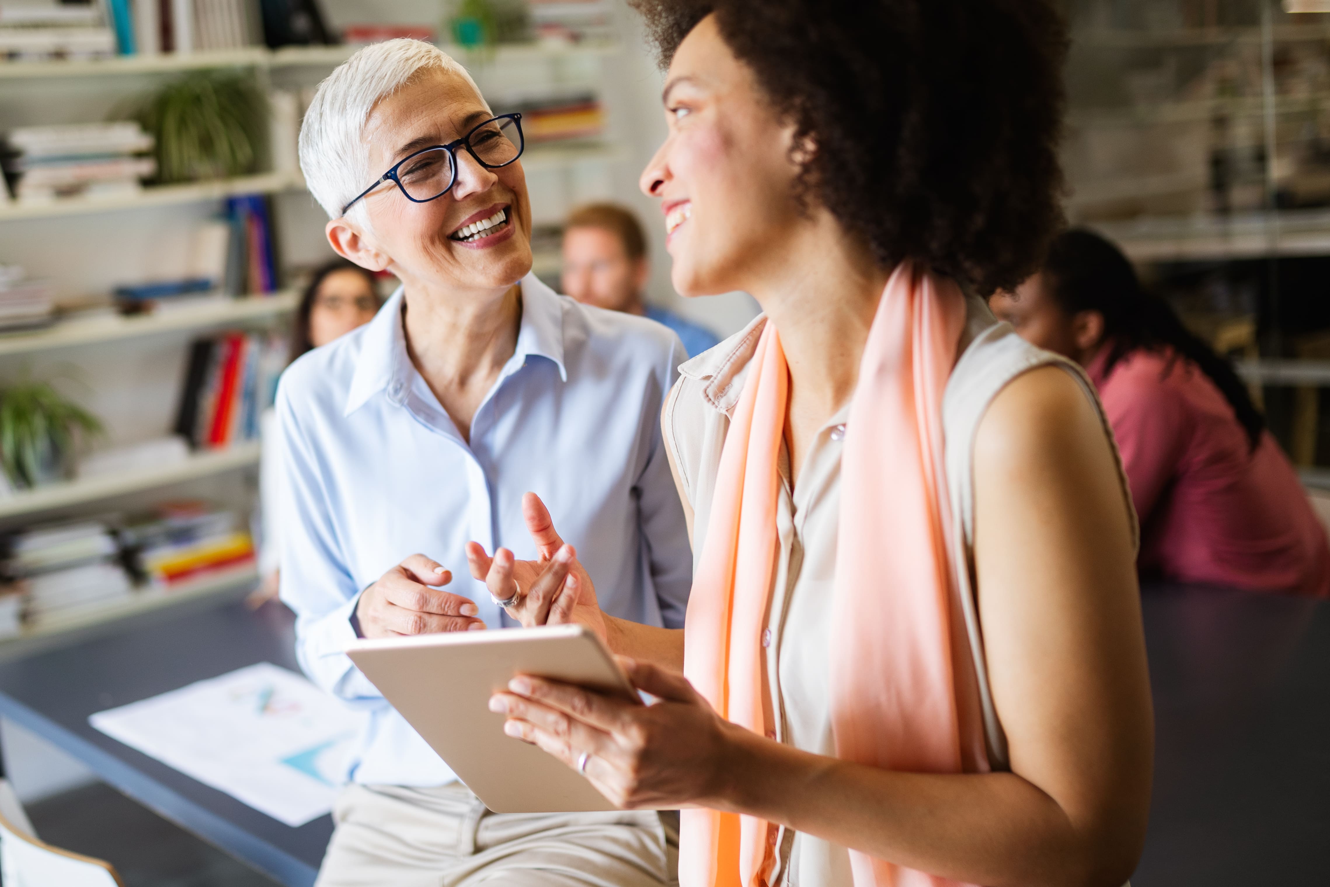 Frauen am Arbeitsplatz lachen miteinander