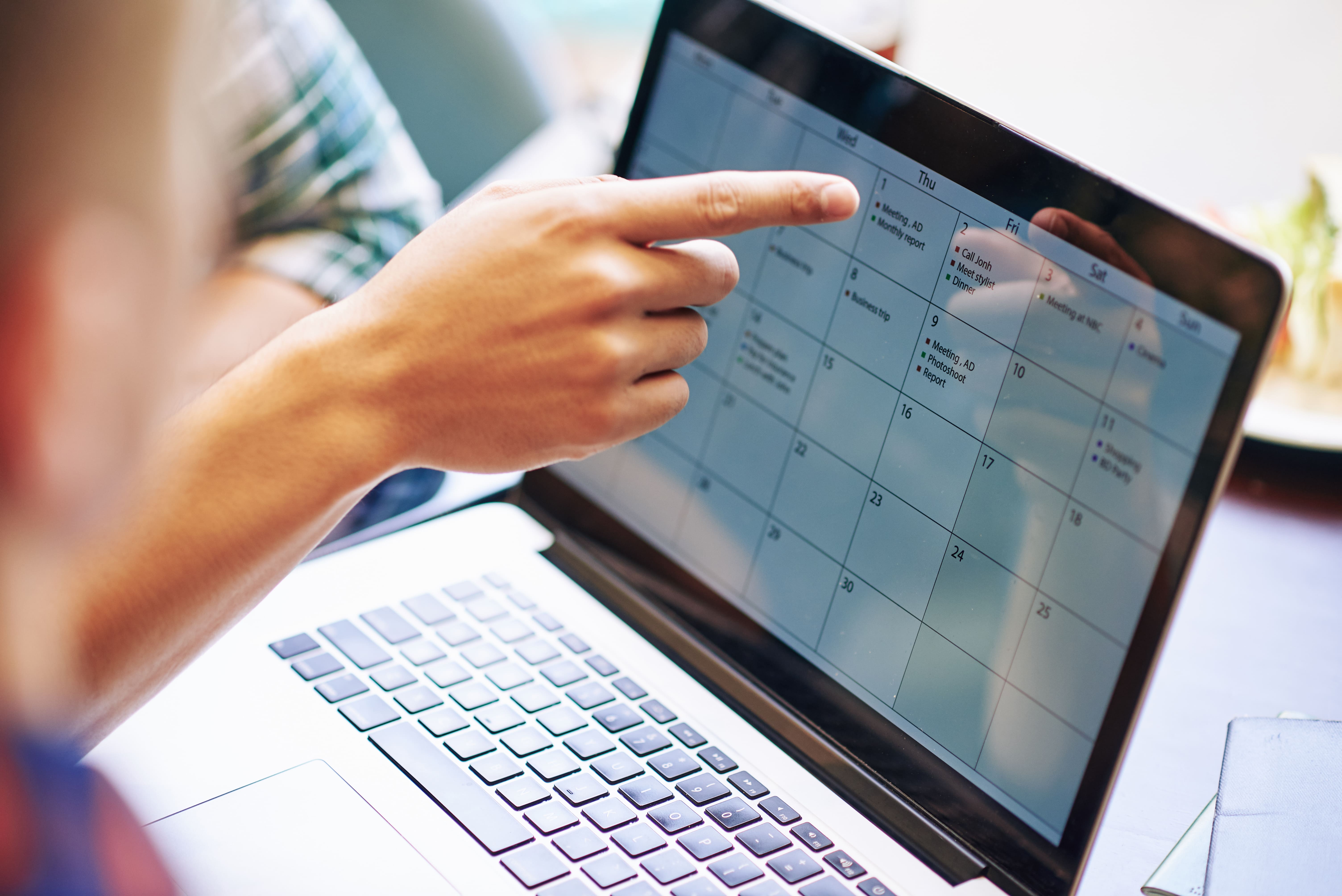 Frau zeigt auf Content Kalender am Laptop