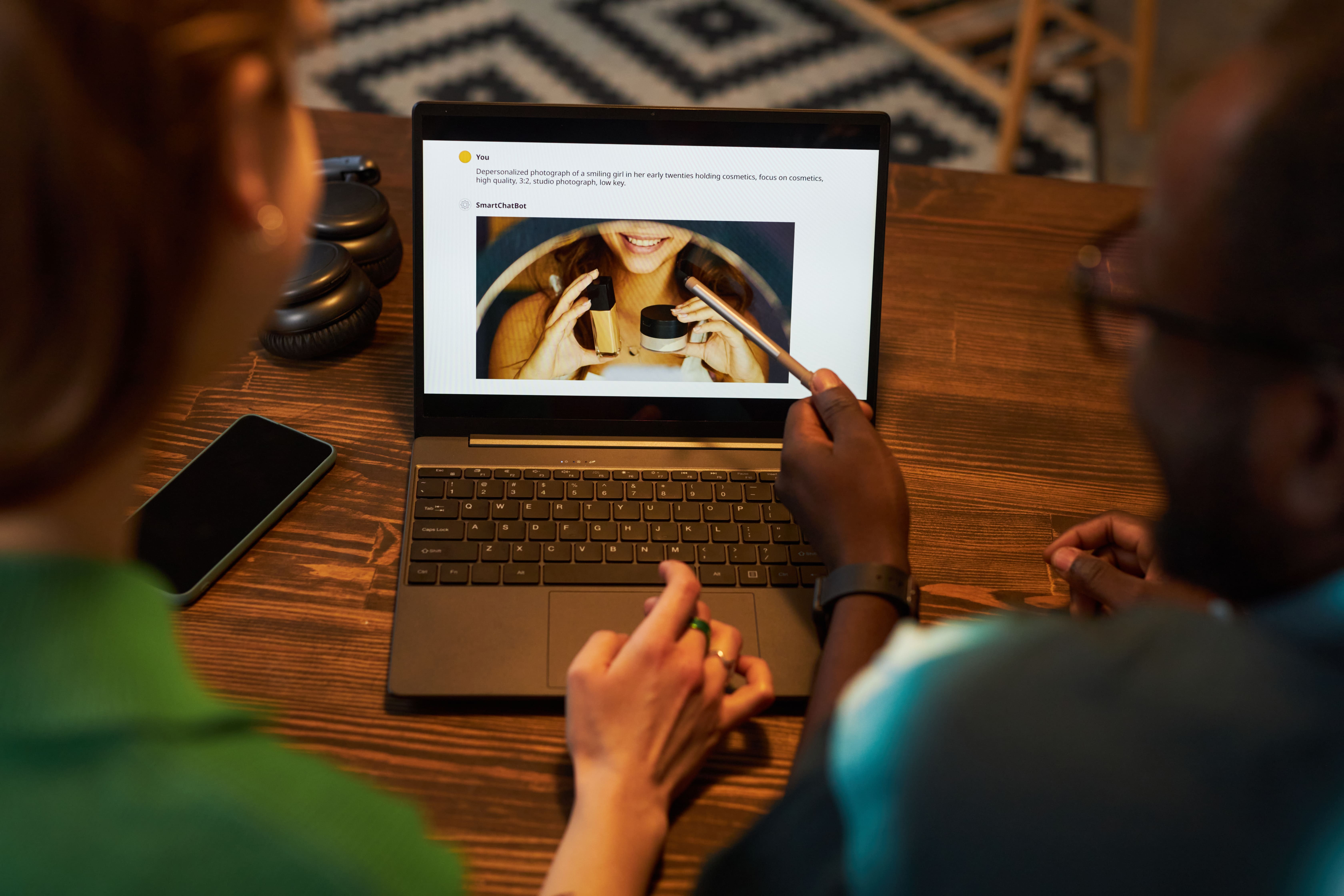 Personen schauen sich Bild auf Laptop an