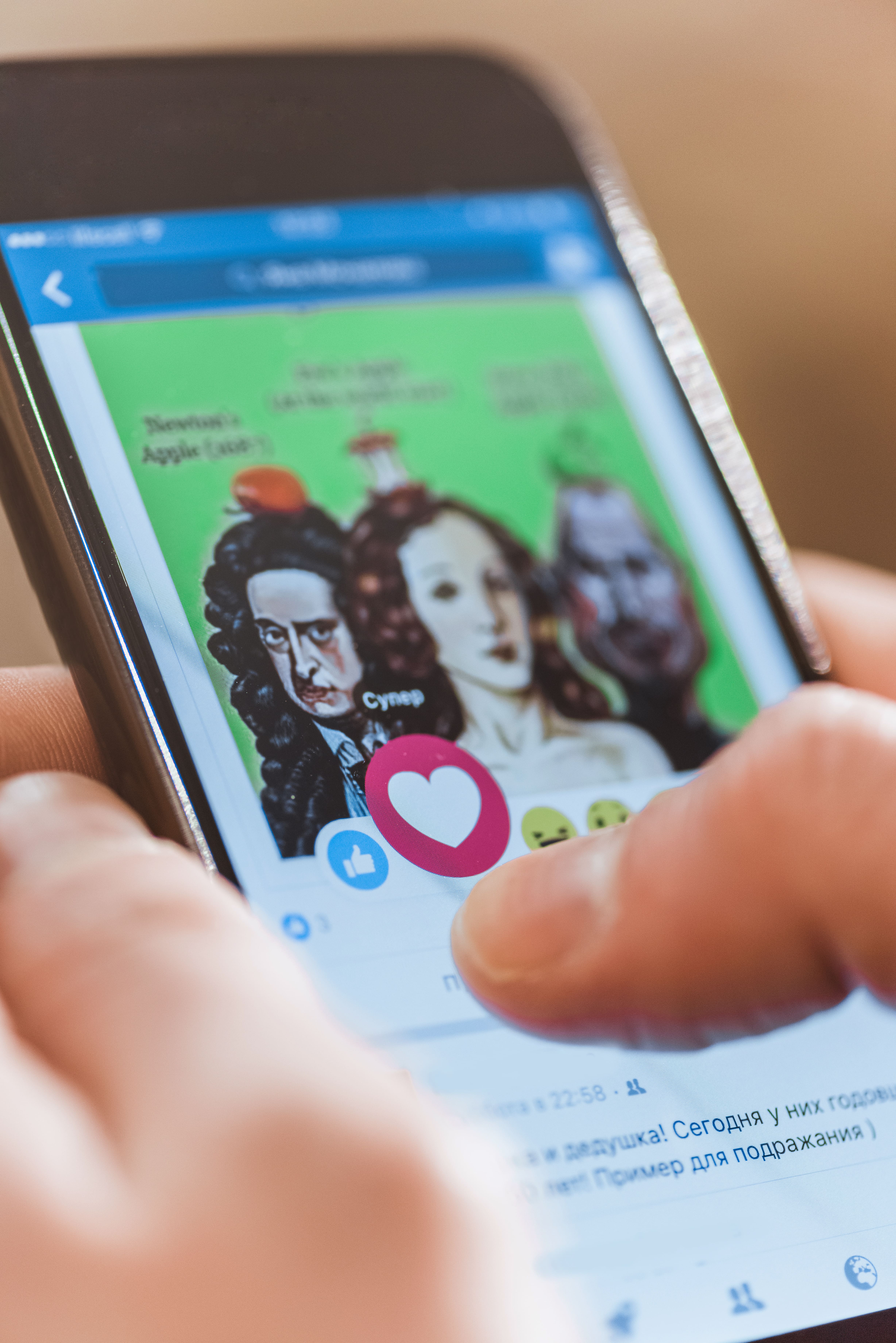 Mann benutzt Smartphone mit Facebook-Anwendung auf dem Bildschirm
