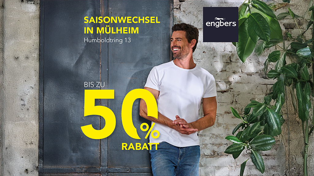 Mann steht vor Wand mit Pflanzen. 50% Engbers Bewerbung