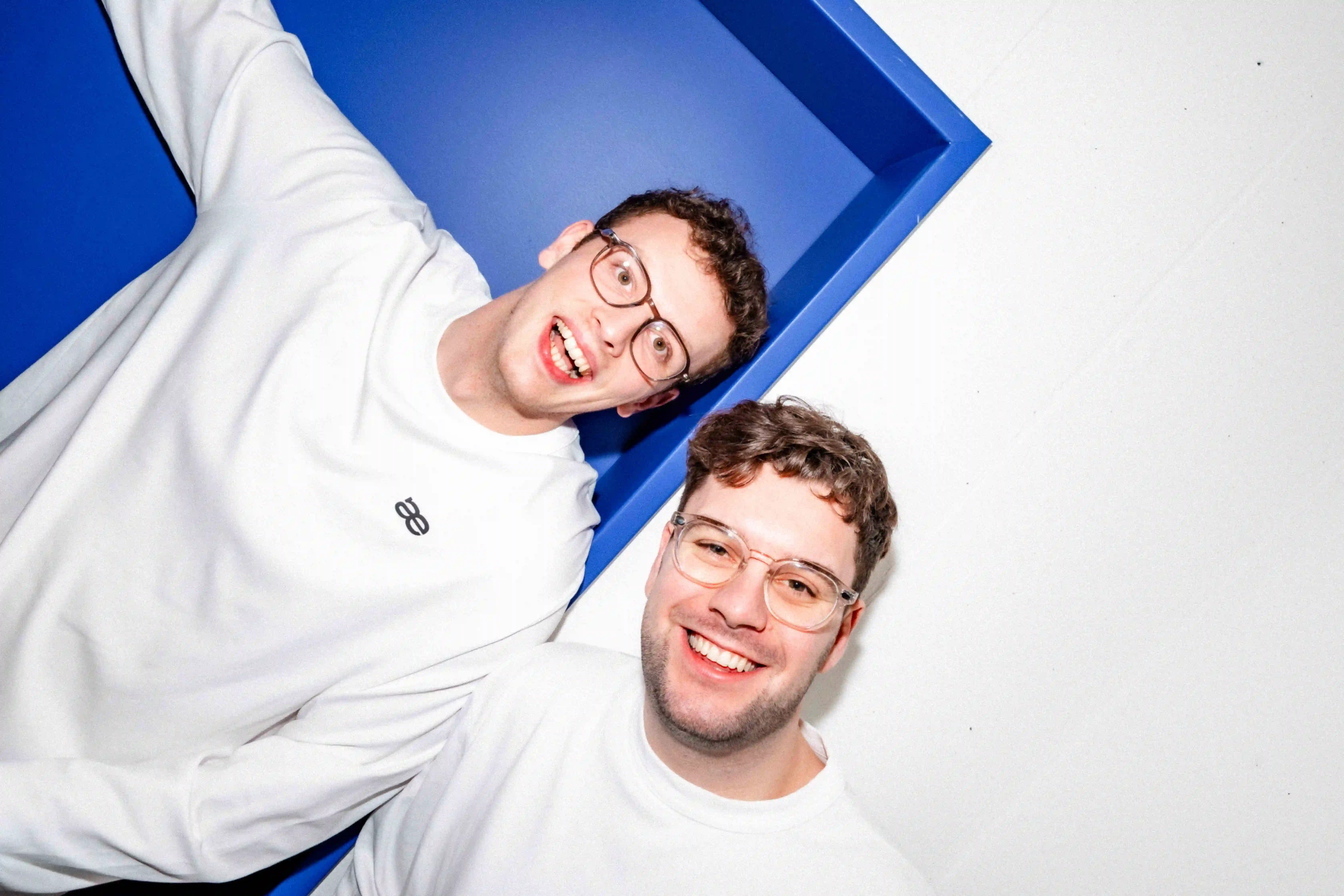 Kim and Tobi from laetters with white laetters shirts in front of a blue door