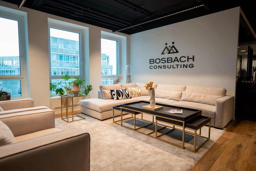 Lounge im Büro von Bosbach Consulting mit Logo an der Wand