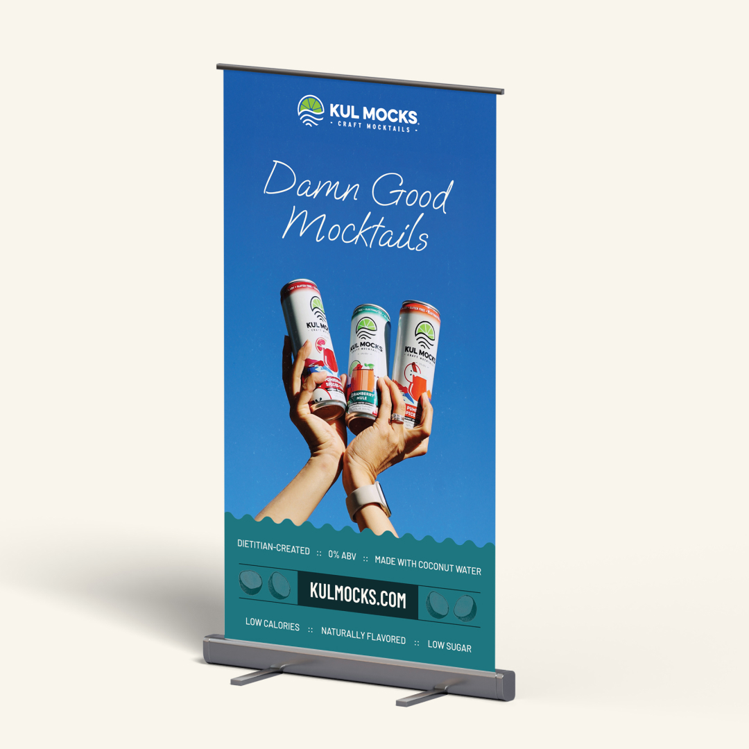 Banner showing hands holding three Kul Mocks craft mocktail cans against a clear blue sky.
