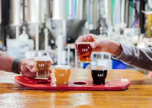 Flagship brews in pint glasses in a skateboard deck holder