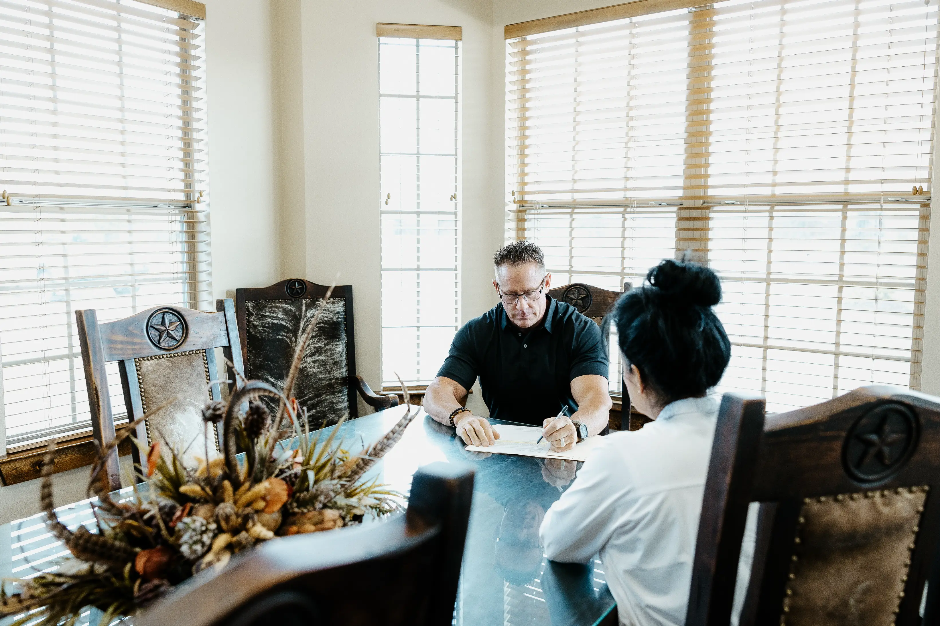 An image of Glen Cox filling out bail bond paperwork at his Quick Release Bail Bonds office in East Texas