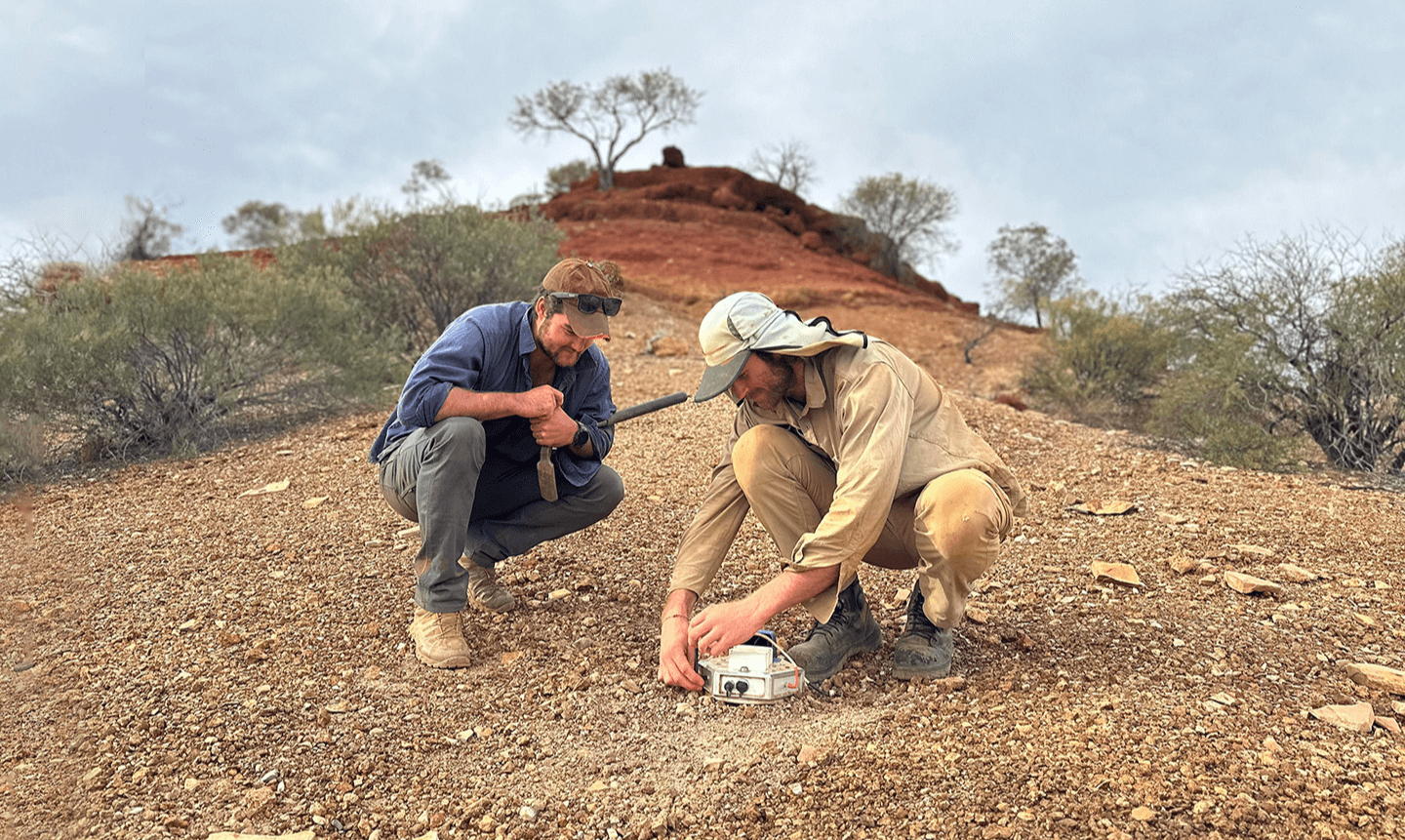 Two people looking at ExoSphere technology on the ground