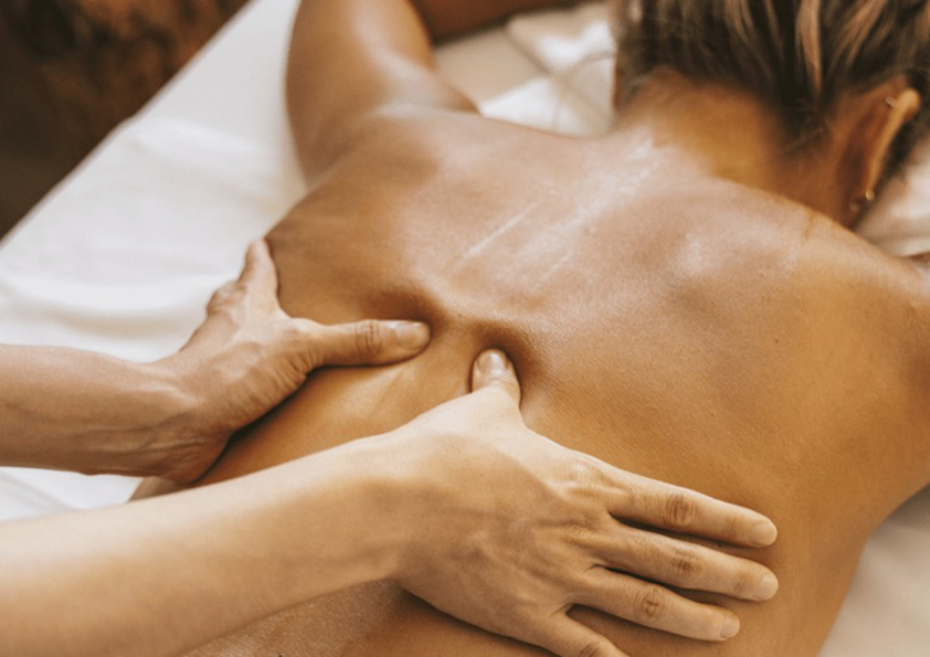 Remedial massage therapist applying deep tissue pressure to a client’s back at Pando Society wellness centre to relieve muscle tension and promote relaxation.