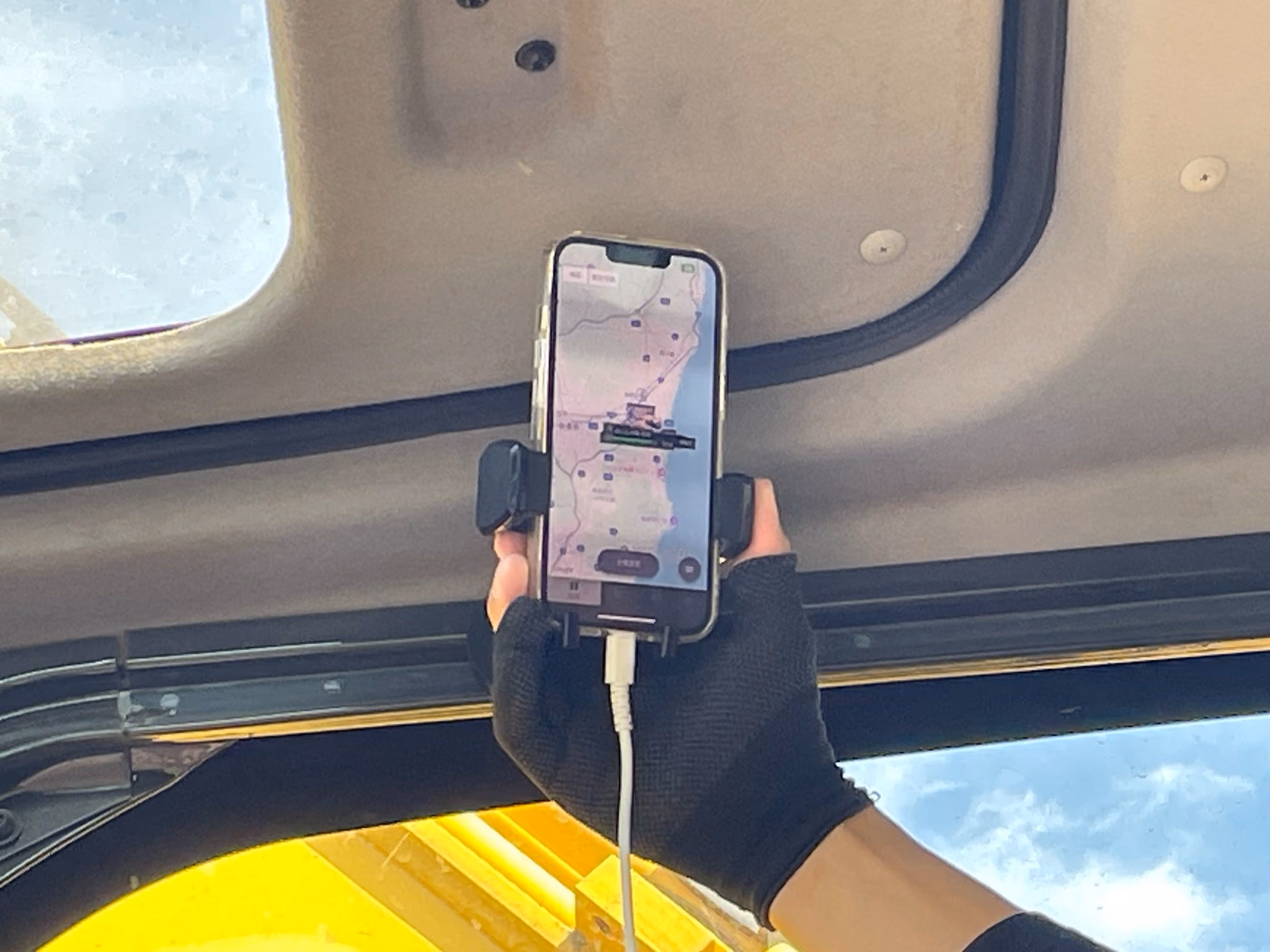 建機の運転席でスマートフォンの地図を確認している様子