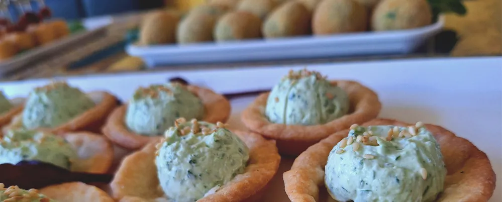 Platten mit Mürbeteigtörtchen mit Käse und Ruccola gefüllt und mit vegetarischer Bechamelkroketten 