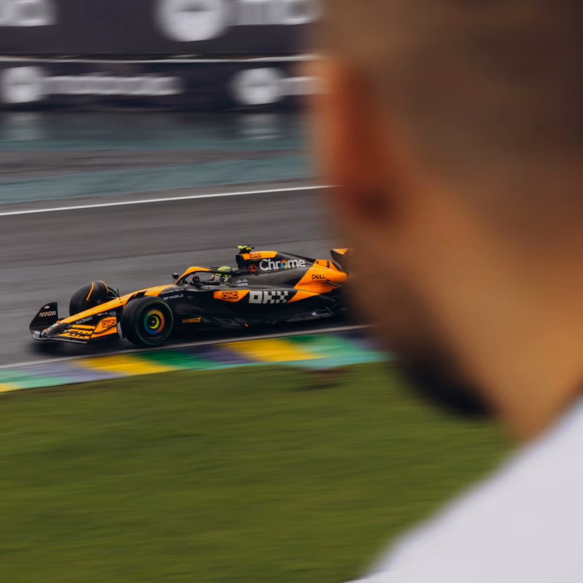 Vue sur la cathédrale de Grossmünster avec ses deux tours jumelles ornées de drapeaux bleus et blancs, derrière des bâtiments traditionnels à Zurich.