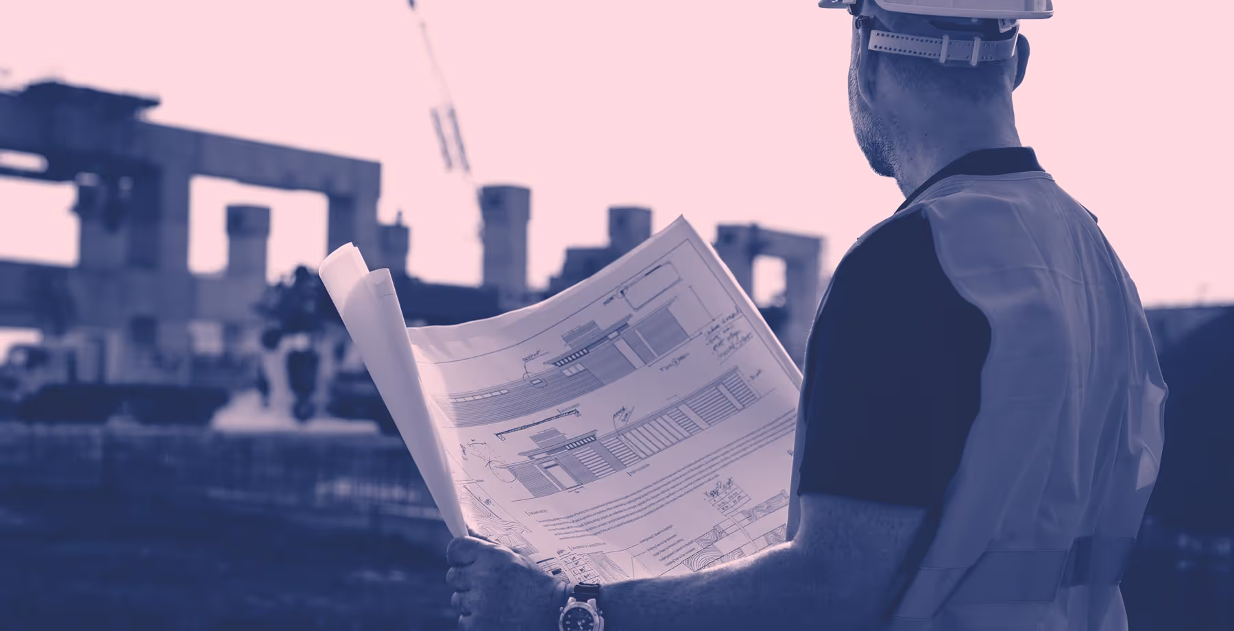 Kontrollansvarig (KA) med hjälm och säkerhetsväst som granskar en byggnadsritning på en byggarbetsplats.