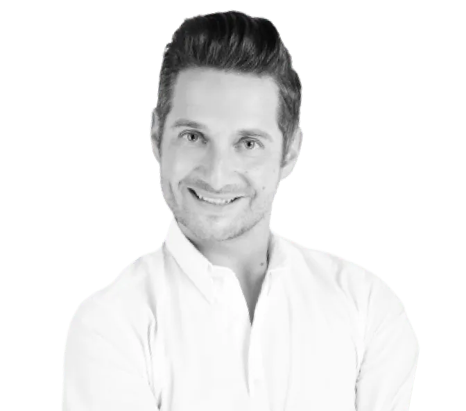 Lächelnder Mann mit dunklem Haar und weißem Hemd vor transparentem Hintergrund.