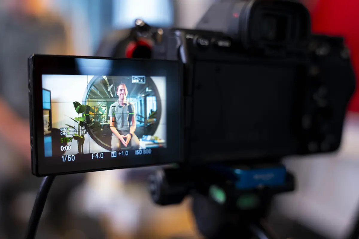 Two men working at desks in a modern office with glass walls, computers, and office chairs.