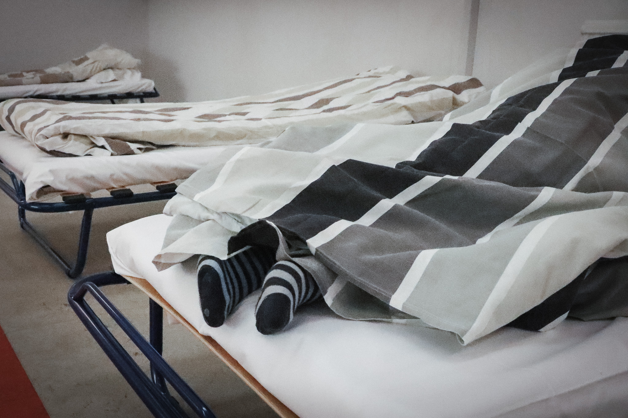 Ett par fötter som sticker fram från täcket i en tältsäng.