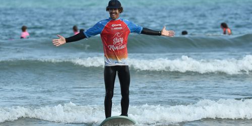 Moniteur de surf souriant les bras ouverts