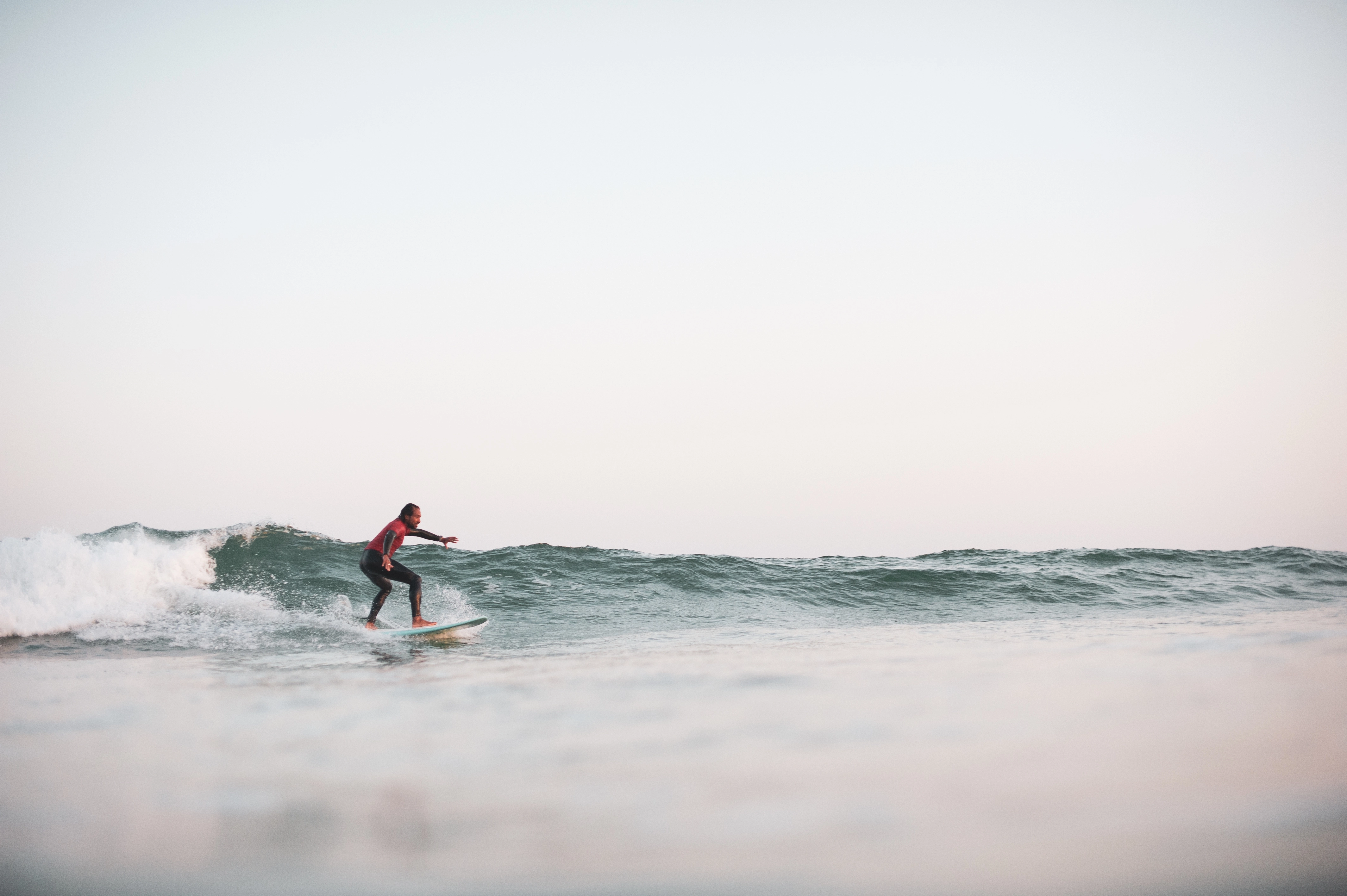 surfeur surfant une vague au large