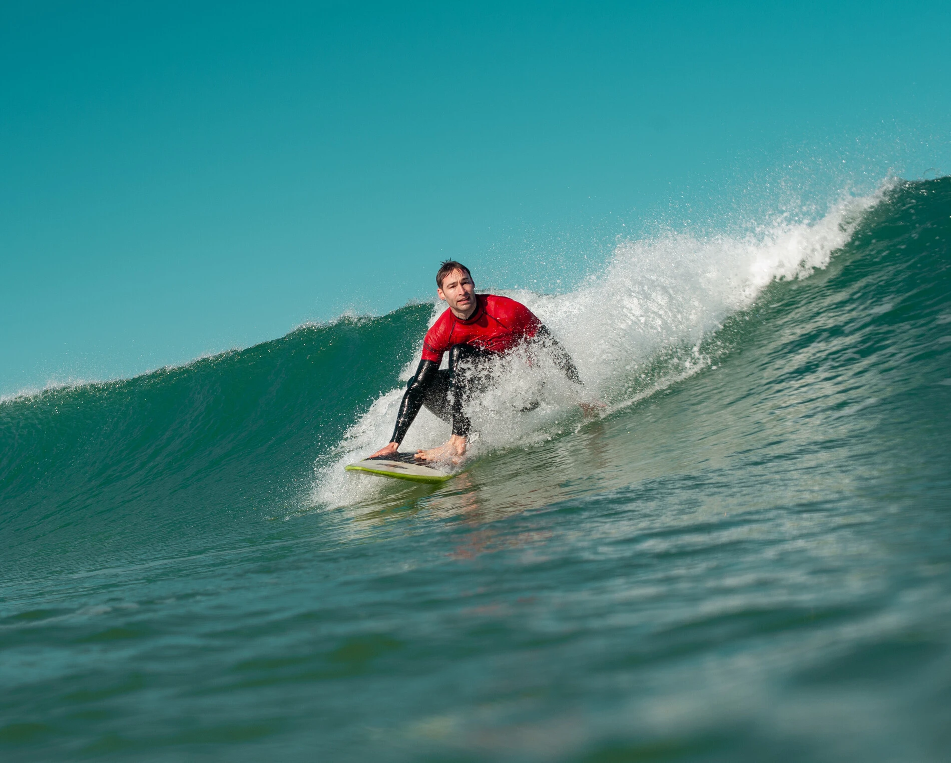 surfeur accroupi sur une vague lisse