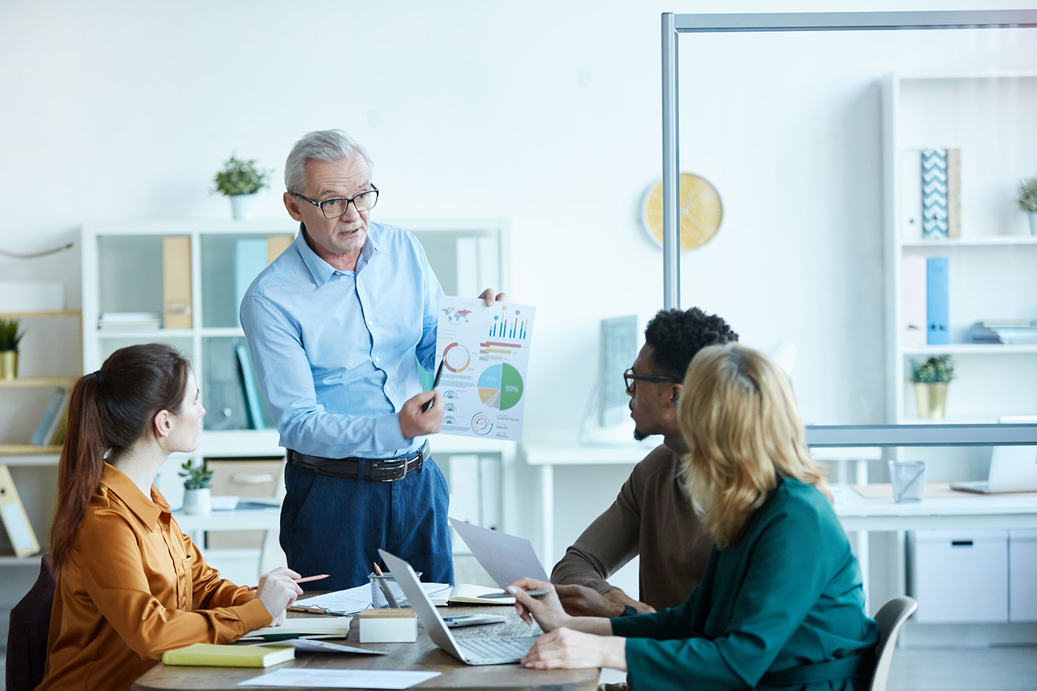 A senior consultant discusses strategy with high-performing employees
