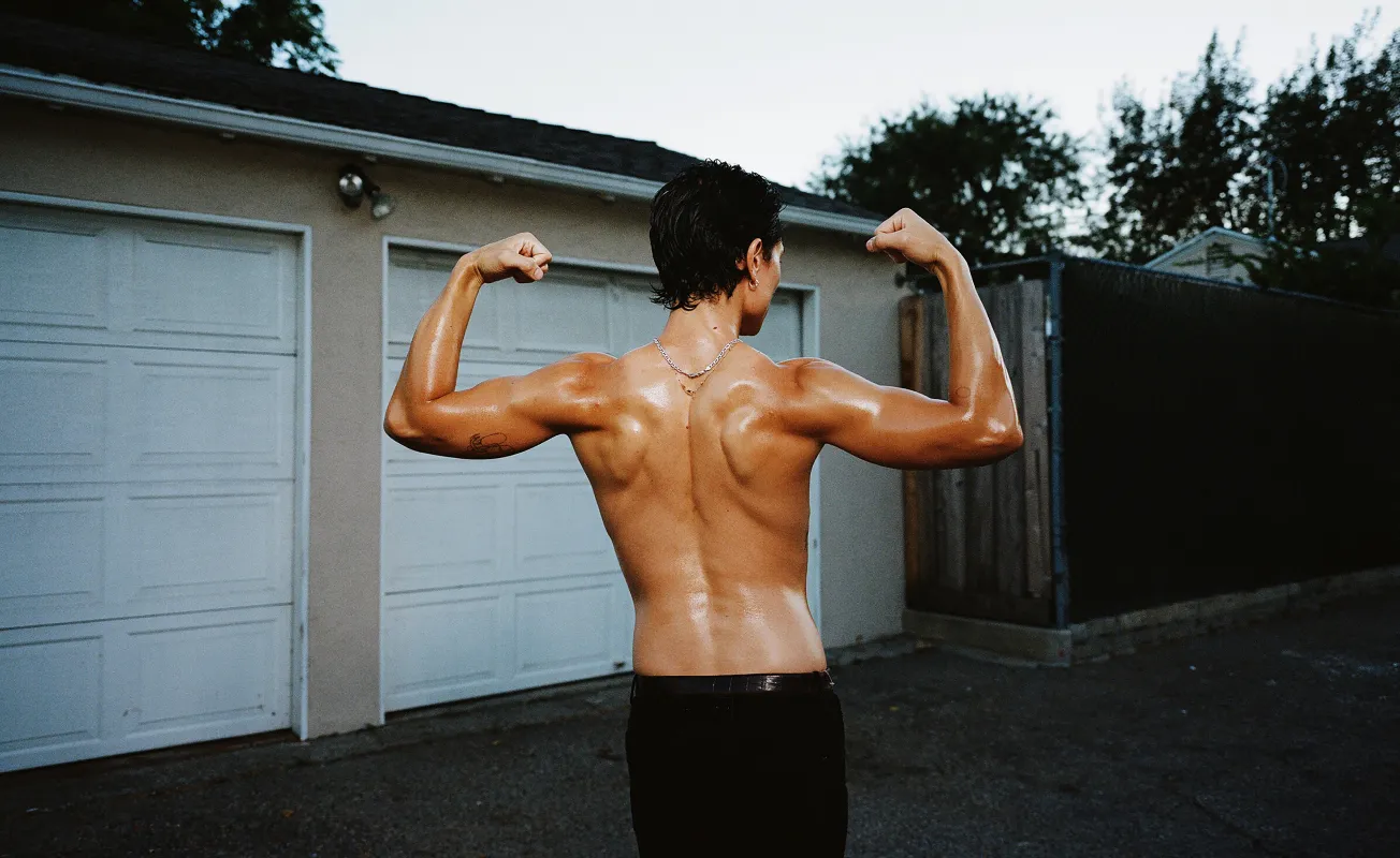 Motorcycle riding on a dirt road winding through a rocky desert canyon landscape.
