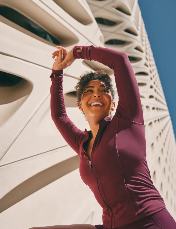 Motorcycle riding on a dirt road winding through a rocky desert canyon landscape.