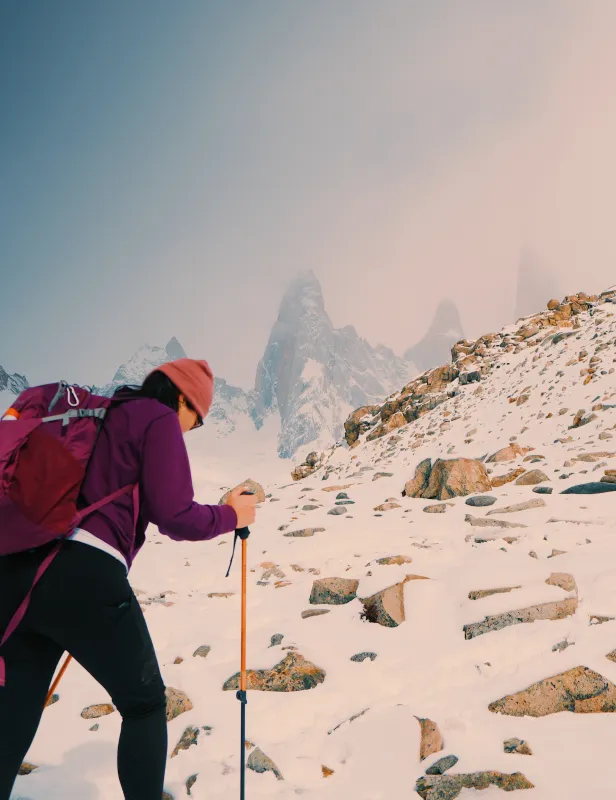 Motorcycle riding on a dirt road winding through a rocky desert canyon landscape.