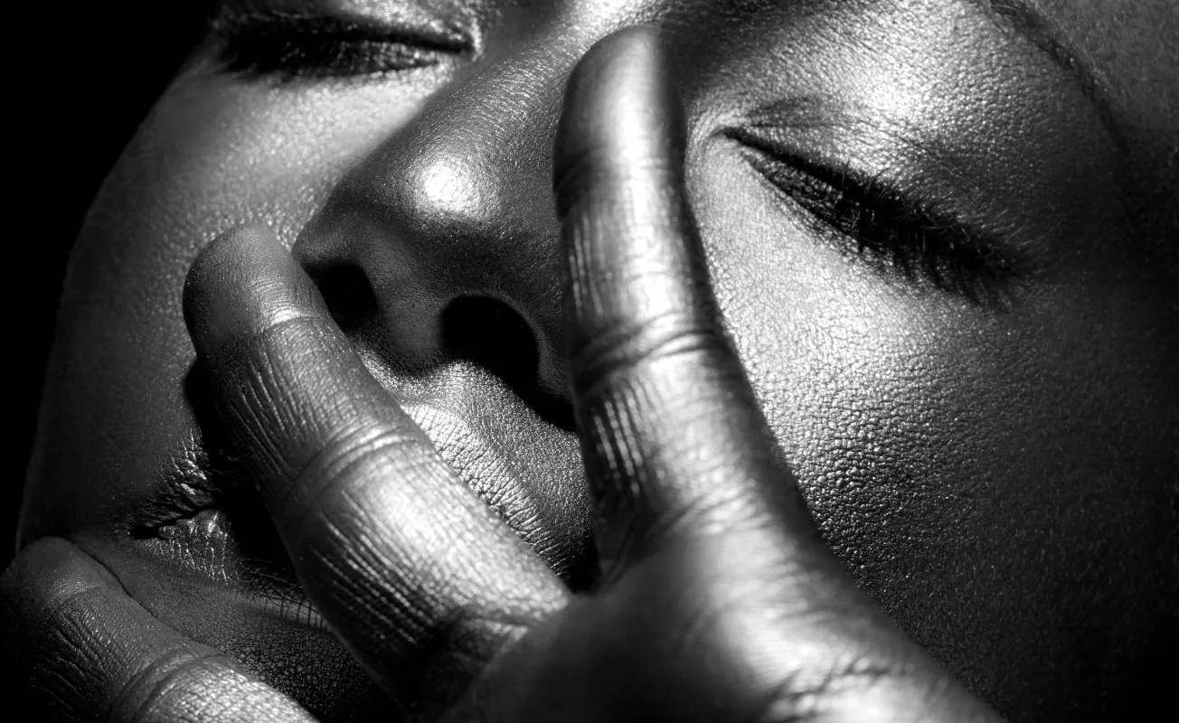 Motorcycle riding on a dirt road winding through a rocky desert canyon landscape.