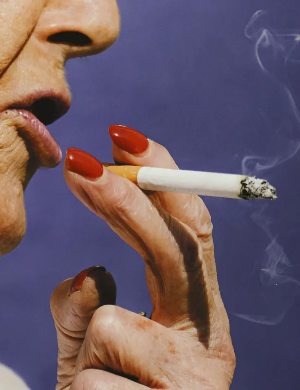 Motorcycle riding on a dirt road winding through a rocky desert canyon landscape.