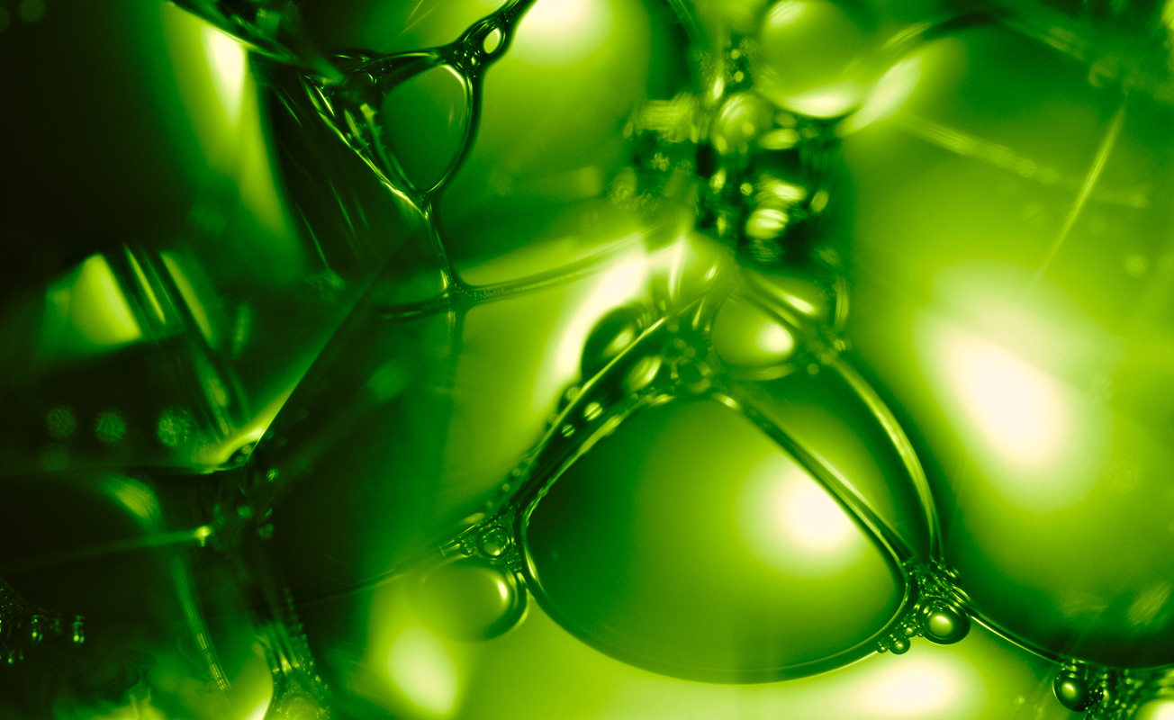 Motorcycle riding on a dirt road winding through a rocky desert canyon landscape.
