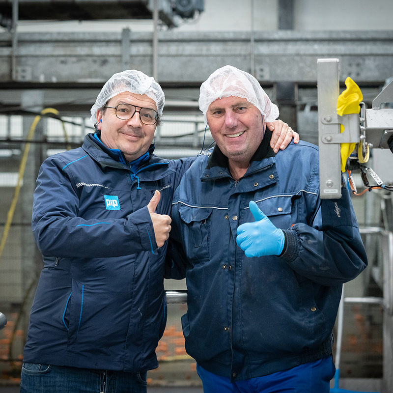 Twee medewerkers met haarnetjes steken hun duim op, PIP Innovations