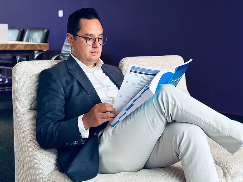Man in pak leest een tijdschrift op de bank, Christian Letselschade Advocatuur