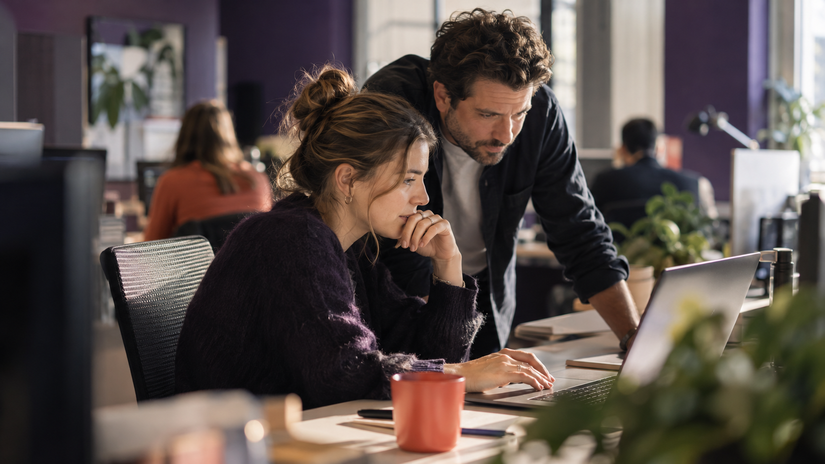 Twee collega's bekijken samen een klantoverzicht op een laptop