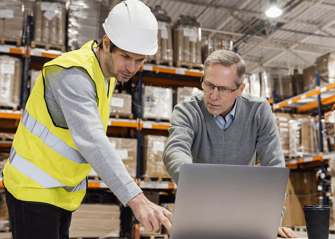 Logistics team reviewing new technology implementation plans in a warehouse setting