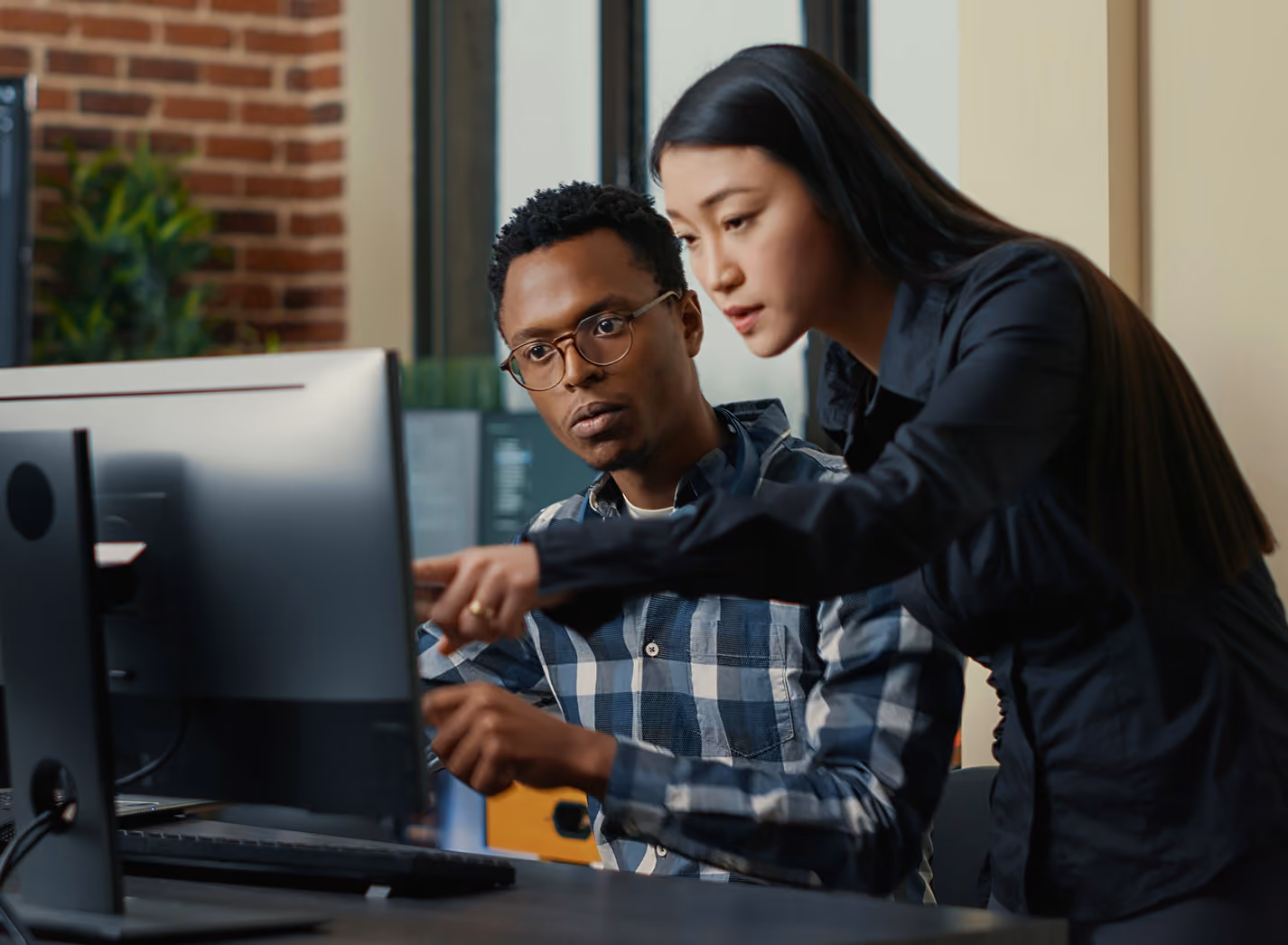 Coworkers looking at a computer in an office