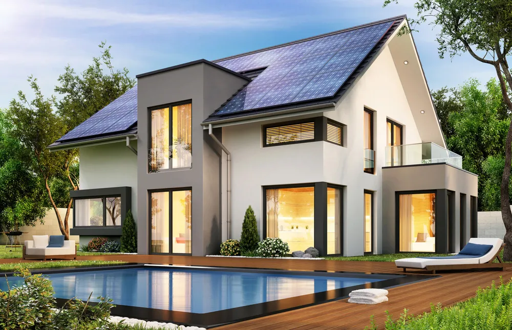 Modern house with solar panels on roof during day with lights on