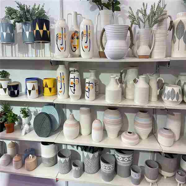 Ceramic cups and vases displayed on showroom shelves.