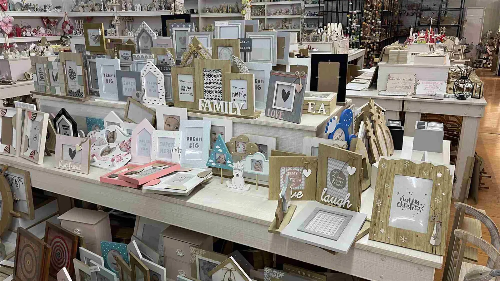 Retail-style shelf display of framed home decor in a showroom.