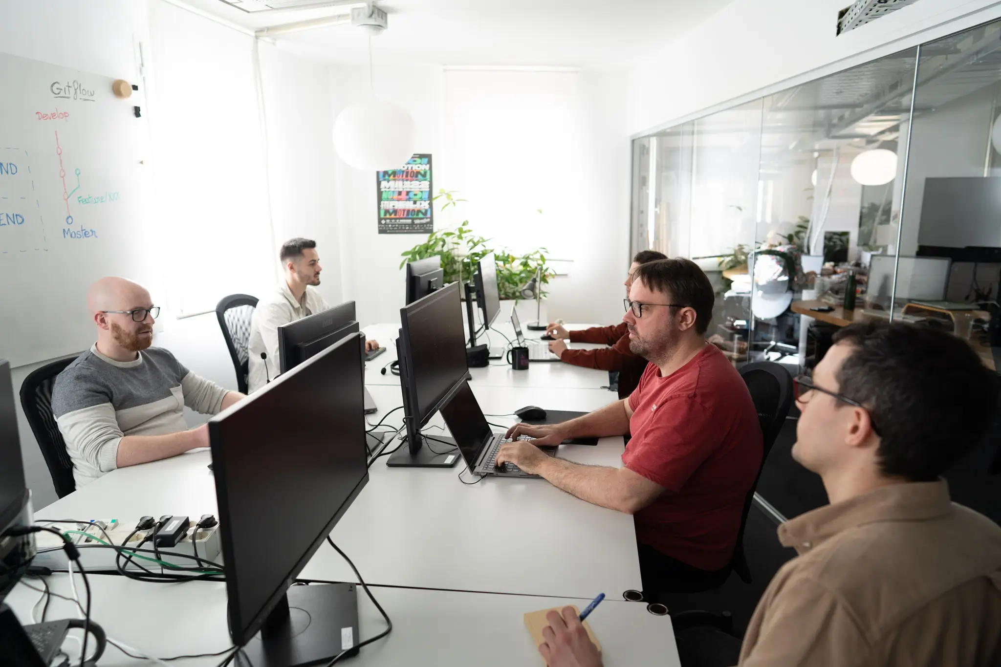 L'équipe technique de Digital Garden en revue devant un tableau de branches Git