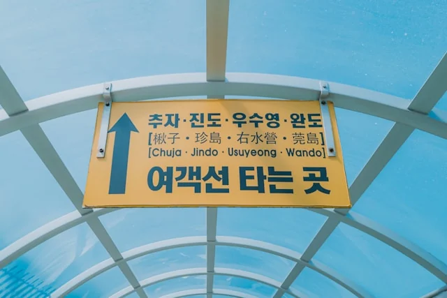A Korean ferry boarding sign pointing toward routes to Chuja, Jindo, Usuyeong and Wando. Photo by Seungmin Yoon on Unsplash