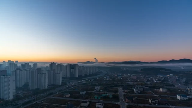 Apartment towers and low-rise buildings at sunset. Photo by rawkkim on Unsplash
