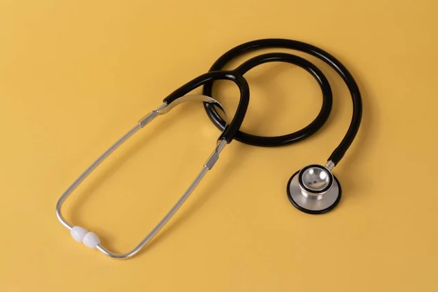 A stethoscope on a yellow surface. Photo by Etactics Inc on Unsplash