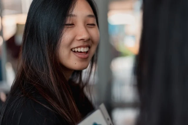 A woman smiling during a conversation. Photo by Varick Bizot on Unsplash
