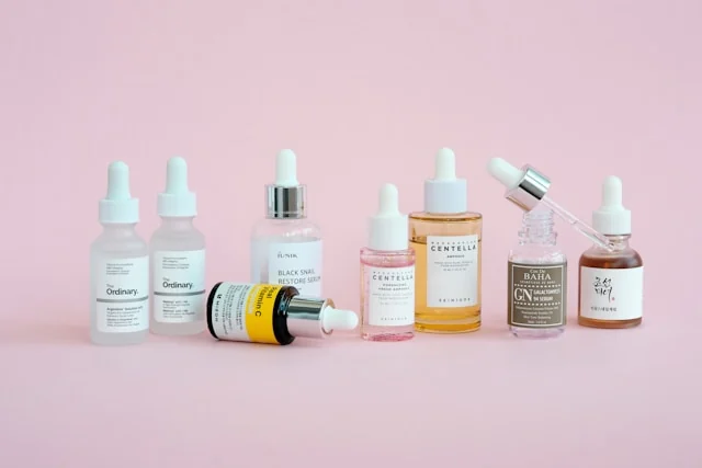 Skincare serum bottles arranged on a pink surface. Photo by Maria Lupan on Unsplash