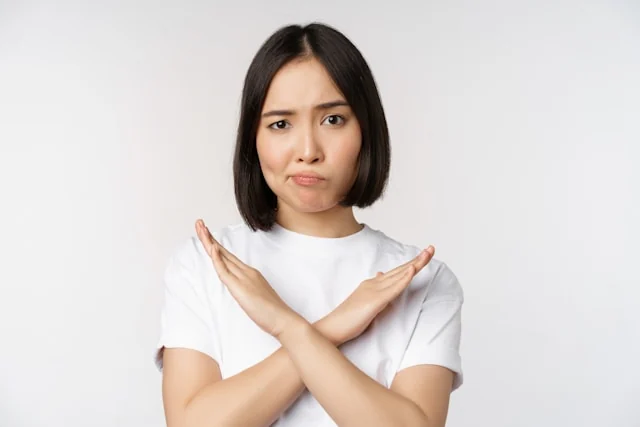 A woman crossing her forearms in an X gesture.