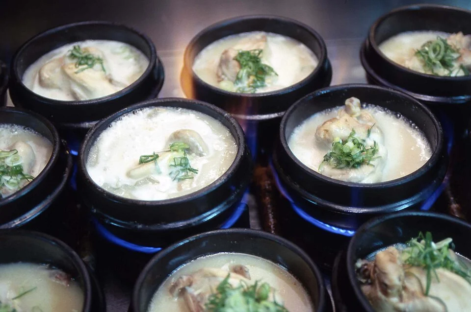 Several hot stone bowls of samgyetang, Korean chicken soup.