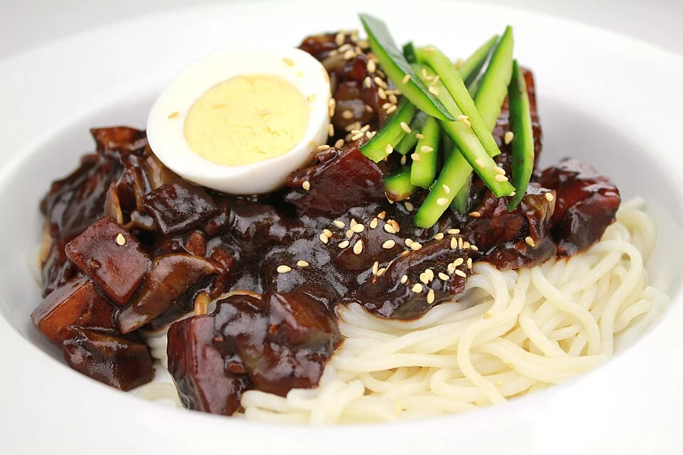 Jajangmyeon noodles topped with black bean sauce, cucumber and half a boiled egg.